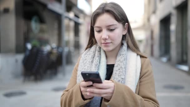 Νεαρή Ξανθιά Γυναίκα Που Χρησιμοποιεί Smartphone Χαλαρή Έκφραση Στο Δρόμο — Αρχείο Βίντεο