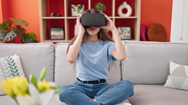 年轻美丽的惊慌失措的女人在家里用虚拟现实眼镜玩电子游戏 — 图库视频影像