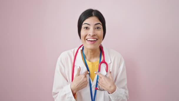 Młoda Piękna Latynoska Lekarz Wskazując Się Zaskoczeniem Odizolowanym Różowym Tle — Wideo stockowe