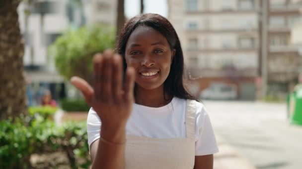 若いアフリカ系アメリカ人女性笑顔自信を持ってやって来るジェスチャーで手で公園 — ストック動画