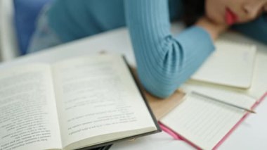Üniversite sınıfındaki masada uyuyan güzel İspanyol bir kız öğrenci.