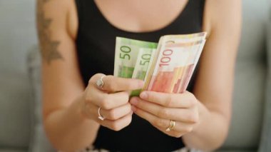 Norveç Kronu 'nu sayan genç bir kadın.