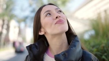 Genç, güzel, İspanyol bir kadın. Parkta kendine güvenen gökyüzüne bakıyor.