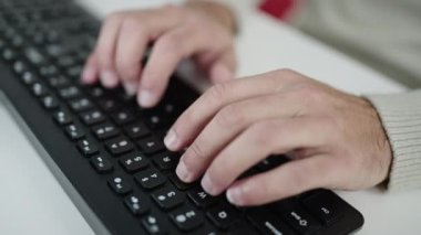 Ofiste bilgisayar klavyesi kullanan genç bir İspanyol.