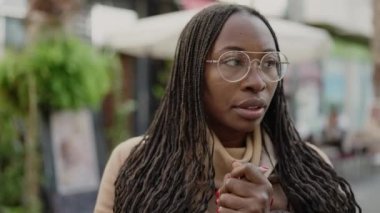 African woman putting scarf for cold weather at street
