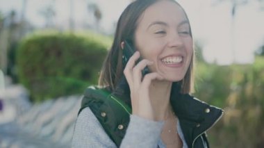 Young beautiful hispanic woman smiling confident talking on smartphone at park
