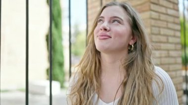 Sokakta kendine güvenen genç sarışın kadın gülümsüyor