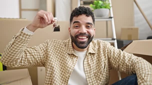 Young Hispanic Man Holding Keys Sitting Floor New Home — Stock Video