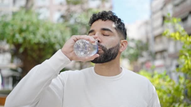 Jonge Spaanse Man Lacht Vol Zelfvertrouwen Drinkt Een Fles Water — Stockvideo