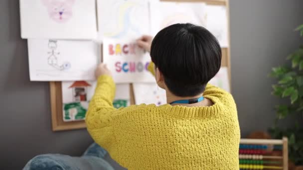Young Chinese Woman Preschool Teacher Hanging Back School Message Cork — Vídeo de stock
