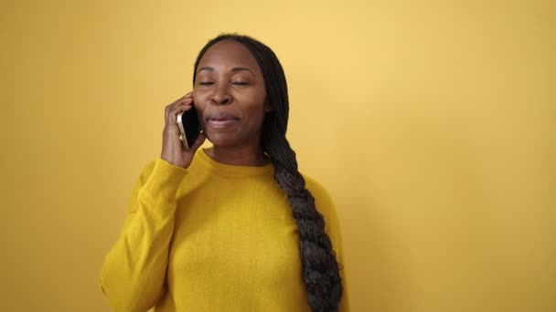Afrikaanse Vrouw Glimlachend Spreken Aan Telefoon Geïsoleerde Gele Achtergrond — Stockvideo