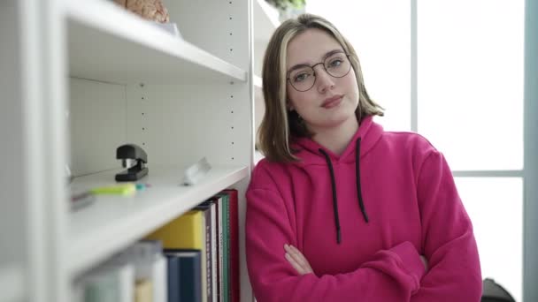 Kollarını Kavuşturup Kütüphanede Kendine Güvenen Genç Sarışın Kız Öğrenci — Stok video