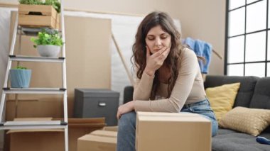 Kanepede oturan genç, güzel İspanyol kadın yeni evini düşünüyor.