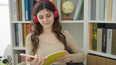 Kütüphanede kitap okuyan güzel İspanyol bir kız öğrenci.