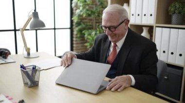 Ofiste dizüstü bilgisayarla çalışan bir iş adamı.