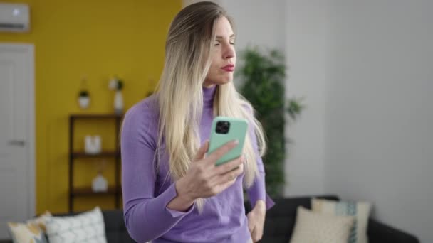 Mladá Blondýna Žena Pomocí Smartphone Vážným Výrazem Doma — Stock video