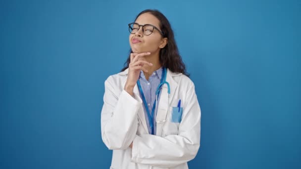 Junge Schöne Hispanische Ärztin Steht Mit Zweifelndem Gesichtsausdruck Vor Isoliertem — Stockvideo