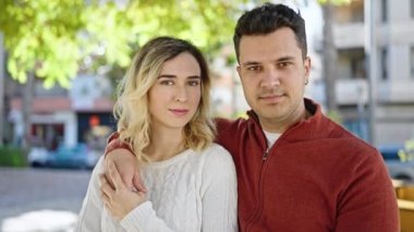 Man and woman couple smiling confident hugging each other at park