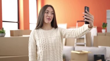 Genç, güzel, İspanyol bir kadın yeni evinde video görüşmesi yapıyor.