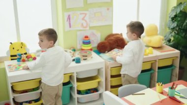 Anaokulunda duran matematik bilmecesiyle oynayan sevimli çocuklar.