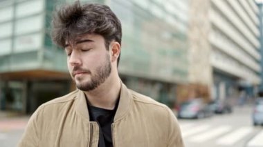 Sokakta üzgün bir ifadeyle dikilen genç İspanyol adam.