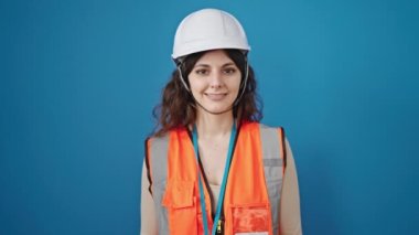 Genç, güzel İspanyol kadın inşaatçı kendine güvenen, izole edilmiş mavi arka planda duran