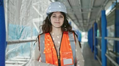 Güzel İspanyol kadın mimar gülümsüyor. Kollarını kavuşturup caddede duruyor.