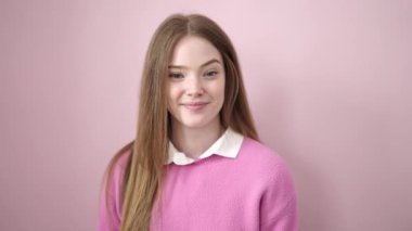 Young blonde woman smiling confident standing over isolated pink background