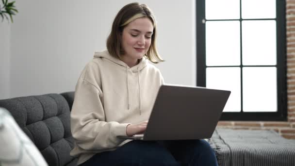 Ung Blond Kvinna Som Använder Laptop Sitter Soffan Hemma — Stockvideo