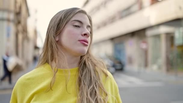 Junge Blonde Frau Steht Mit Entspanntem Gesichtsausdruck Auf Der Straße — Stockvideo