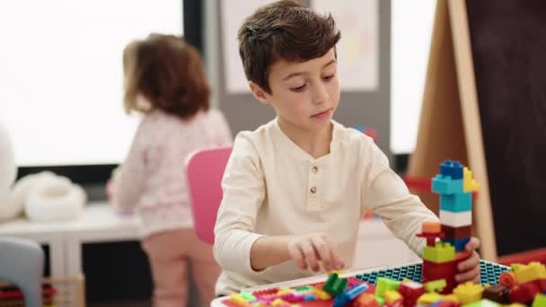 Очаровательный Мальчик Девочка Играют Строительными Блоками Сидя Столе Детском Саду — стоковое видео