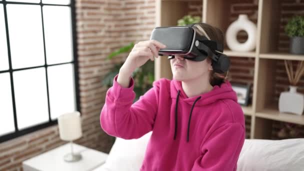 年轻的金发女人在卧室用虚拟现实眼镜玩电子游戏 — 图库视频影像