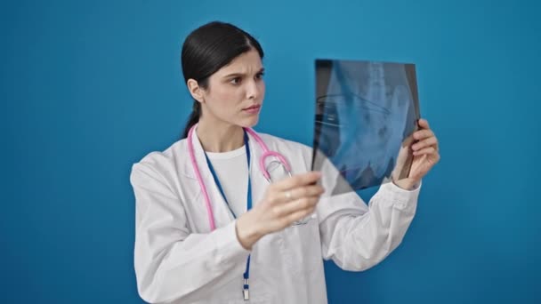 Fiatal Gyönyörű Spanyol Orvos Keres Röntgen Elszigetelt Kék Háttér — Stock videók