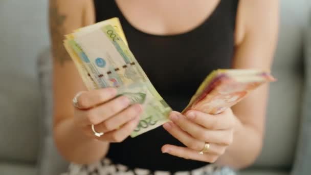 在家里数着菲律宾比索钞票的年轻女人 — 图库视频影像