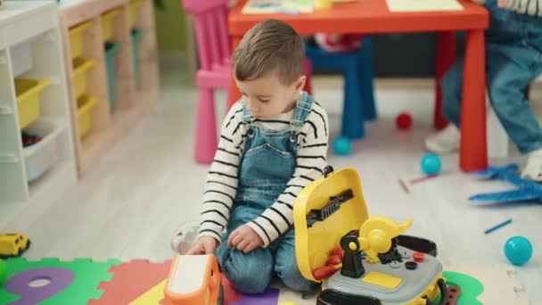Uroczy Chłopcy Siedzący Podłodze Bawiący Się Zabawkami Samochodowymi Przedszkolu — Wideo stockowe
