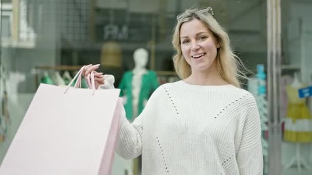 Junge Blonde Frau Geht Einkaufen Und Zeigt Auf Taschen Und — Stockvideo