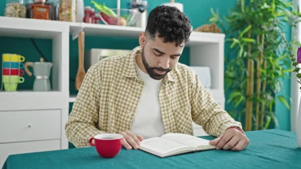 Jonge Spaanse Man Drinkt Koffie Leesboek Eetzaal — Stockvideo