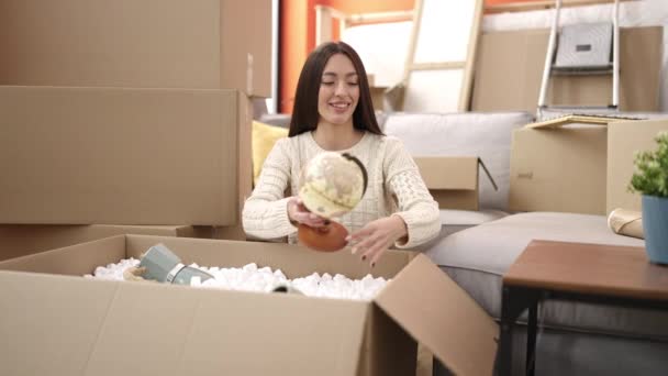 Young Beautiful Hispanic Woman Smiling Confident Unpacking Cardboard Box New — Stock Video