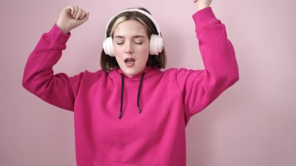 Молода Блондинка Слухає Музику Танцює Над Ізольованим Рожевим Тлом — стокове відео