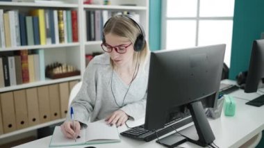 Kütüphane üniversitesinde not defterini gösteren sarışın genç bir kadın.