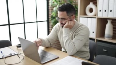 Young hispanic man business worker using laptop working at office