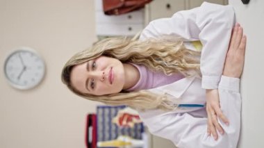 Genç sarışın kadın doktor klinikte tıbbi danışmanlık yapıyor.