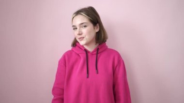 Young blonde woman smiling confident standing over isolated pink background