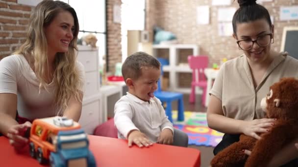 Вчителі Хлопчиком Дівчиною Грають Машинами Іграшкою Лялькою Сидячи Столі Дитячому — стокове відео