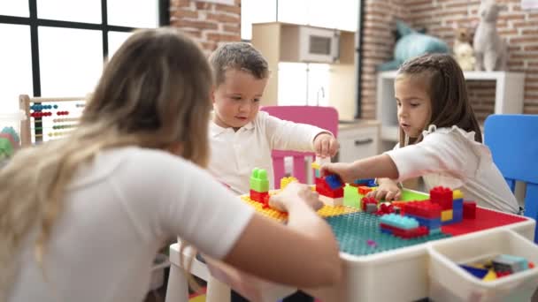 Teacher Boy Girl Playing Construction Blocks Sitting Table Kindergarten — Wideo stockowe