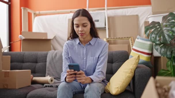Mujer Hispana Hermosa Joven Usando Teléfono Inteligente Sentado Sofá Nuevo — Vídeos de Stock