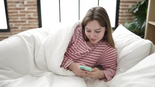 Jeune Femme Blonde Utilisant Smartphone Couché Sur Lit Dans Chambre — Video