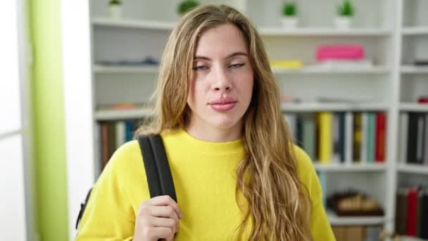 Sırt Çantası Takan Genç Sarışın Öğrenci Kütüphanede Rahat Bir Ifadeyle — Stok video