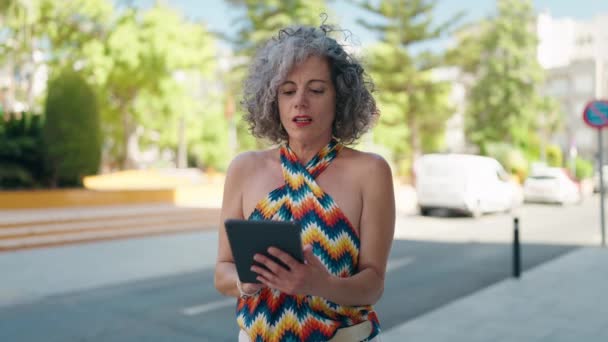 中年灰发女子在街上用有获胜表情的触摸板 — 图库视频影像