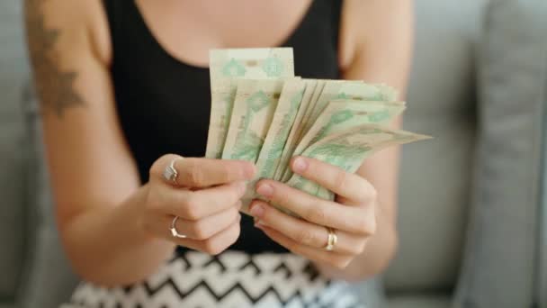 年轻女子在家里数着10枚迪拉姆钞票 — 图库视频影像